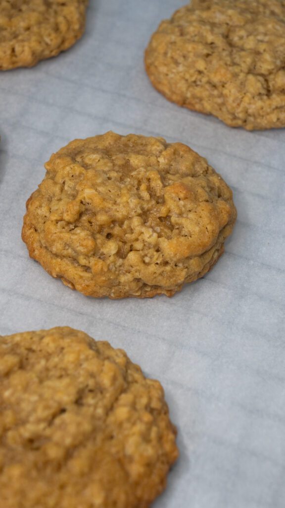 homemade oatmeal cream pie cookie on parchment paper and a baking sheet